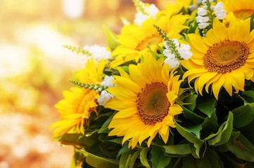 Arrangement of flowers with a large yellow sunflower.