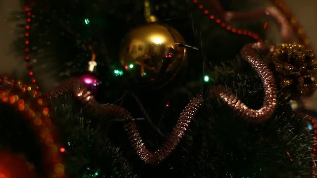 Flashing Christmas lights garland on a Christmas tree decorated with Christmas balls