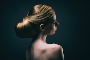 Portrait d'une jeune femme portant un chignon, de profil 