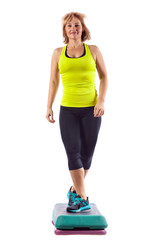 Beautiful blond young woman performing step aerobics exercise