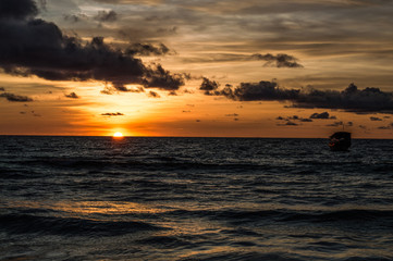 Boat in Front of a Sunset at Lonely Beach on Cambodia's Koh Rong Island