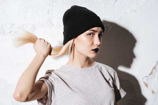 Hipster in black hat holding her hair