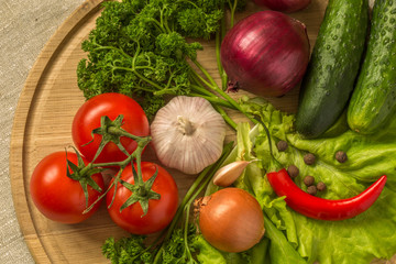 raw vegetables on a round wooden Board. top view.