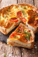 Delicious sliced pie with feta cheese, tomatoes and herbs closeup. Vertical