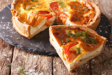 Delicious sliced pie with feta cheese, tomatoes and herbs closeup. horizontal