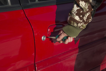 Otwieranie zamka samochodu za pomocą kluczyka. Zamykanie zamka samochodu za pomocą kluczyka. Męska dłoń wkłada kluczyk do zamka samochodu - obrazy, fototapety, plakaty