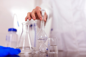 Hand of a Scientist Holds Laboratory Glassware
