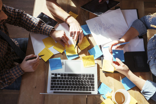 Cropped image of colleagues working at table in office