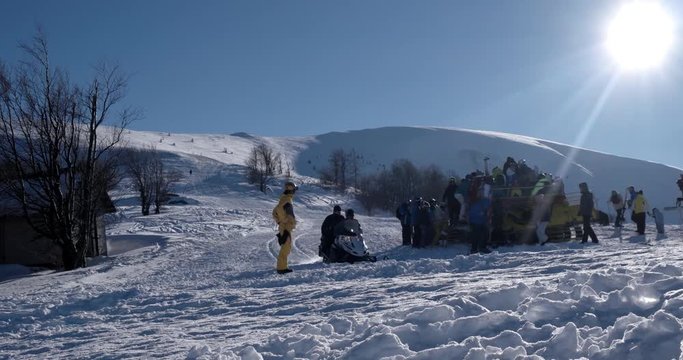 Skiers Loading to the Back of a Snowcat on a Snow Covered Mountain at a Winter Sunny Day Time Lapse