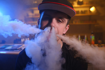 Vaping man in a cloud of vapor in a vape bar. close-up.