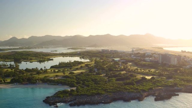 St Maartin Aerial v13 Flying low panning with airport, Mullet Bay and golf course views at sunrise.