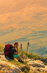 Fototapeta na wymiar Hiker Resting on Rocks in Mountains