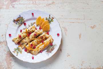 Thin crepes or pancakes with fresh pumpkin confiture, on a rustic wooden background with copy space.