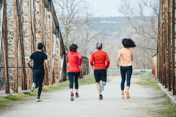 Group of people running together outside, preparing for the marathon