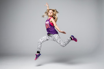 Sporty young woman jumping isolated on white background