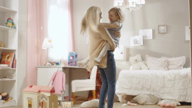 Young Sweet Mother Holds Her Little Cute Daughter in Arms and Spins with Her. Children's Room is Pink and Full of Toys. Slow Motion. Shot on RED EPIC-W 8K Helium Cinema Camera.