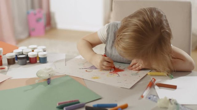 Cute Little Girl Sits at Her Table and Draws with Crayons. Her Room Is Pink and Cosy. Shot on RED EPIC-W 8K Helium Cinema Camera.