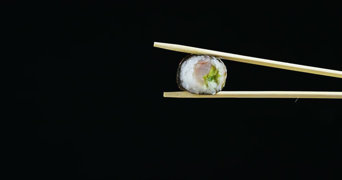 Macro shot of sushi,sashimi,uramaki and nighiri.typical Japanese dish consisting of rice, salmon or tuna,shrimp and fish eggs on a black background.Concept:Japanese restaurant,sushi,oriental tradition