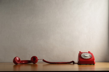 Occupied Retro Red Telephone  with Receiver Trailing across Desk