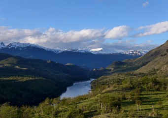 Fototapeta na wymiar River flowing through a lush green mountainous landscape in Patagonia. 