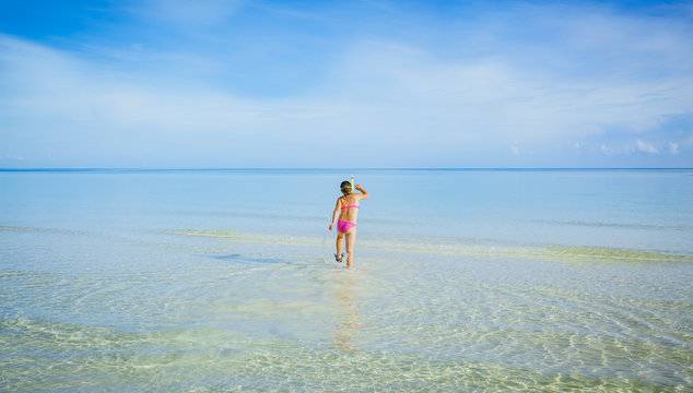Gorgeous amazing, beautiful morning at Cuban Cayo Coco island with little girl walking in the ocean to swim 