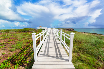 Fototapeta premium Amazing gorgeous beautiful view of a gazebo path leading toward the beach and ocean against magic blue sky background on Cuban Cayo Guillermo Island 