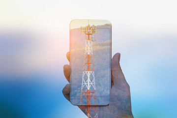 hand hold mobile smartphone double exposure with telecom tower