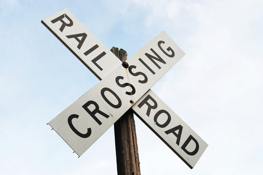 railroad crossing sign against sky