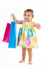 Little girl standing with colorful paper bags isolated on white background.