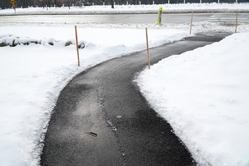 winding sidewalk after snow with snow removed