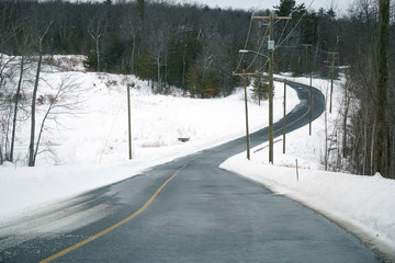 countryside road winding in land after snow