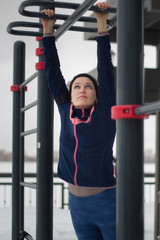 Fototapeta na wymiar Young sport woman doing power exercises on work out fitness at snow winter park