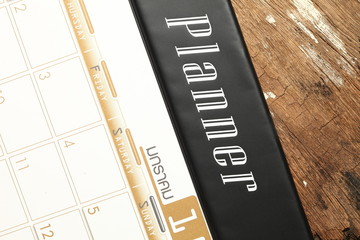 The desk planner put on brown color hardwood surface represent the business planning concept related idea.