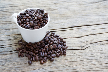 Cup coffee and coffee beans on wooden background