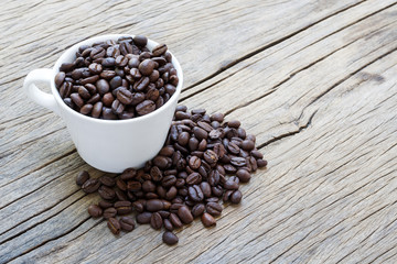 Cup coffee and coffee beans on wooden background