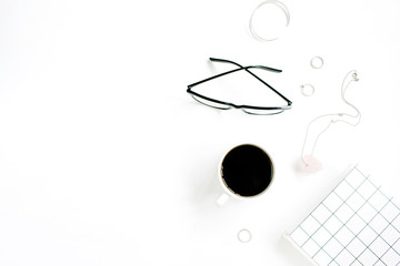 Coffee cup, notebook, glasses and female accessories on white background. Flat lay, top view