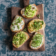 Range of healthy sandwiches with avocado, hummus, ricotta, cucumber, sunflower sprouts, micro...