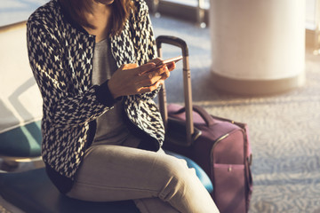 Young woman using smartphone while waiting at the airport