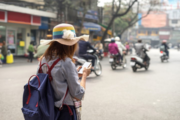 Young traveller using an app on her smartphone