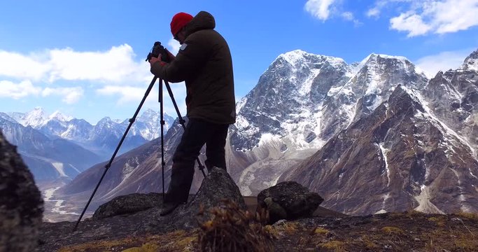  Man makes photos, in the mountains of Nepal. Photo tour to the base camp of Mount Everest. Ama Dablam view, from Awi peak, 5200 m). Awi peak is a part of Everest Base Camp trek. 