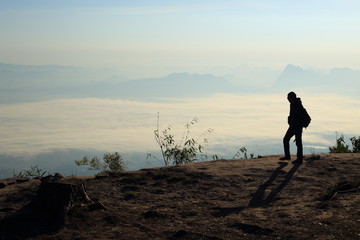 Fototapeta premium Man walking on the cliffs and mist at Phu Kradung National Park,Thailand