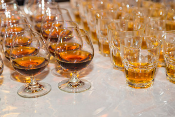 Glasses are filled with whiskey on the table
