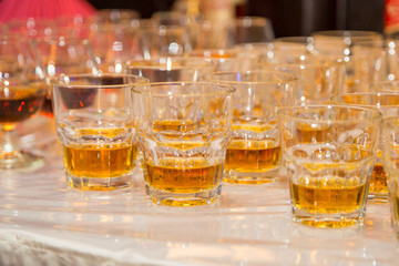 Glasses are filled with whiskey on the table