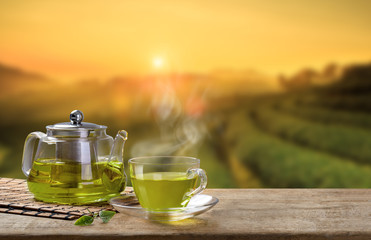 Green Tea cup and glass jugs or jars. with and Green tea leaf sacking on the wooden table and the...