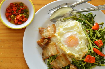 stir fried water mimosa with crispy topping egg on rice
