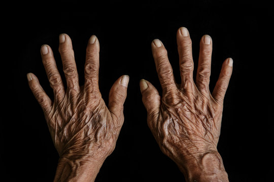The old woman's hands on black background
