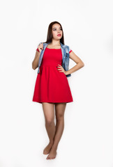 beautiful young woman dressed in a red dress holding a lollipop, studio shot