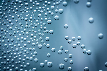 Air bubbles on the wall of the vessel with water close-up as a background.