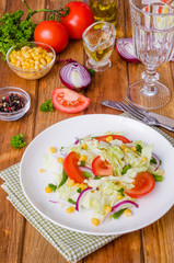 Salad with Chinese cabbage, tomatoes, corn, green beans and onion. Healthy dish.