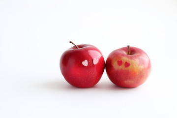 Two lovely red apples with hearts eyes on white background. fresh fruit apple. symbol of love, Valentine's day. minimal style. element for design. copy space